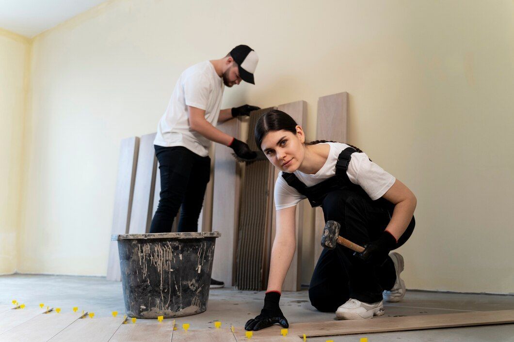 A man and woman collaborating on tiling a room with wooden flooring