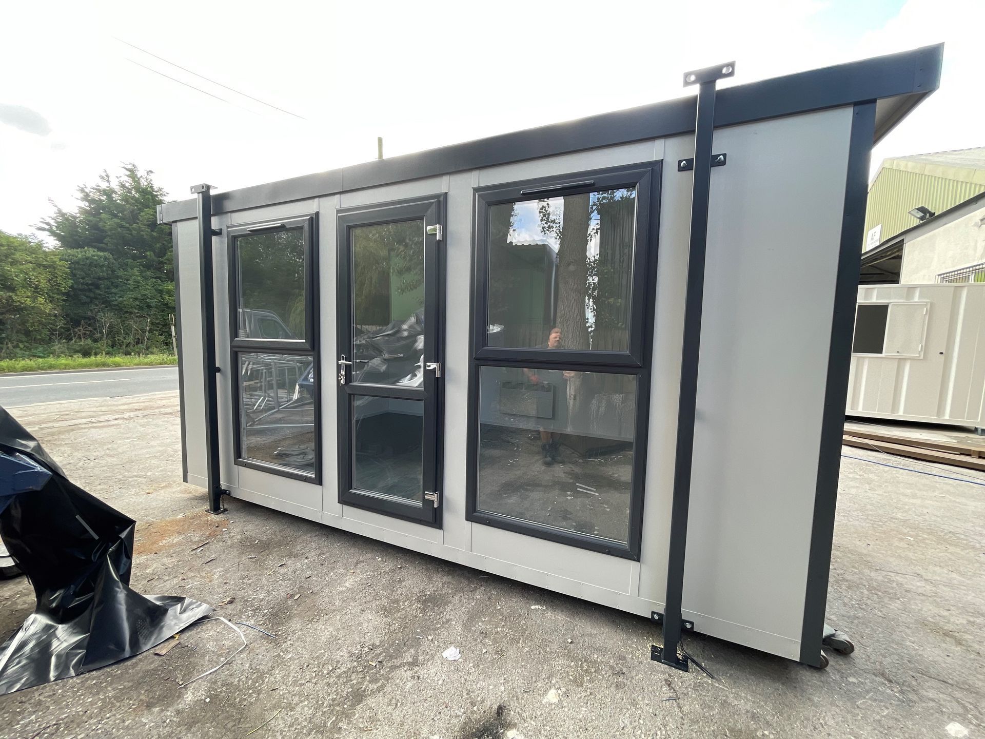 A modular office container featuring multiple windows and a door on its side