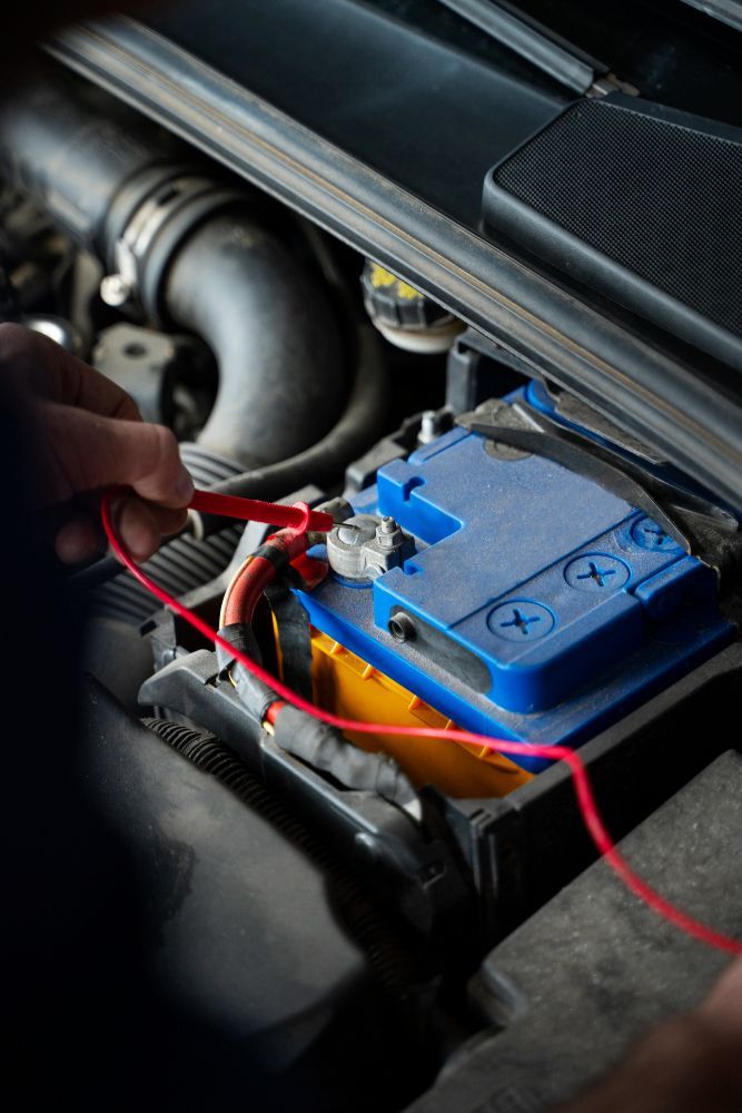 A person is charging a car battery with a charger.