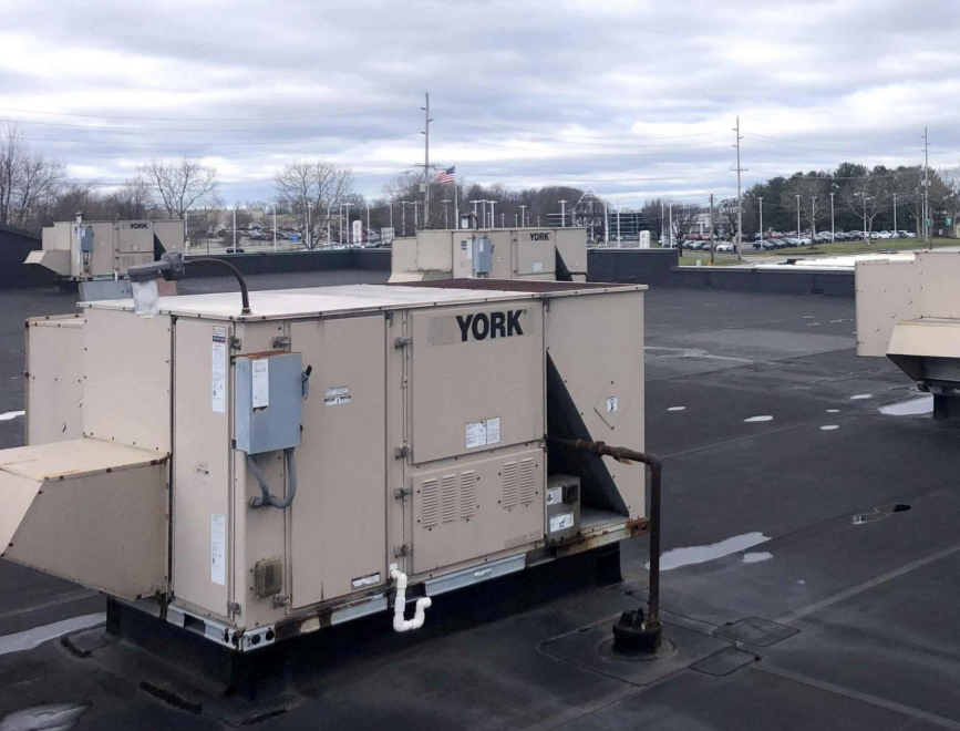 York HVAC units on a flat roof, cloudy sky background.