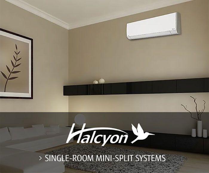 Halcyon mini-split system installed in a modern living room.  White air conditioner unit above long black shelf.