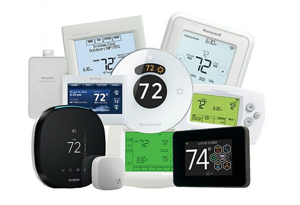 Assortment of Honeywell thermostats, various shapes and sizes, displaying temperature readings in digital displays.
