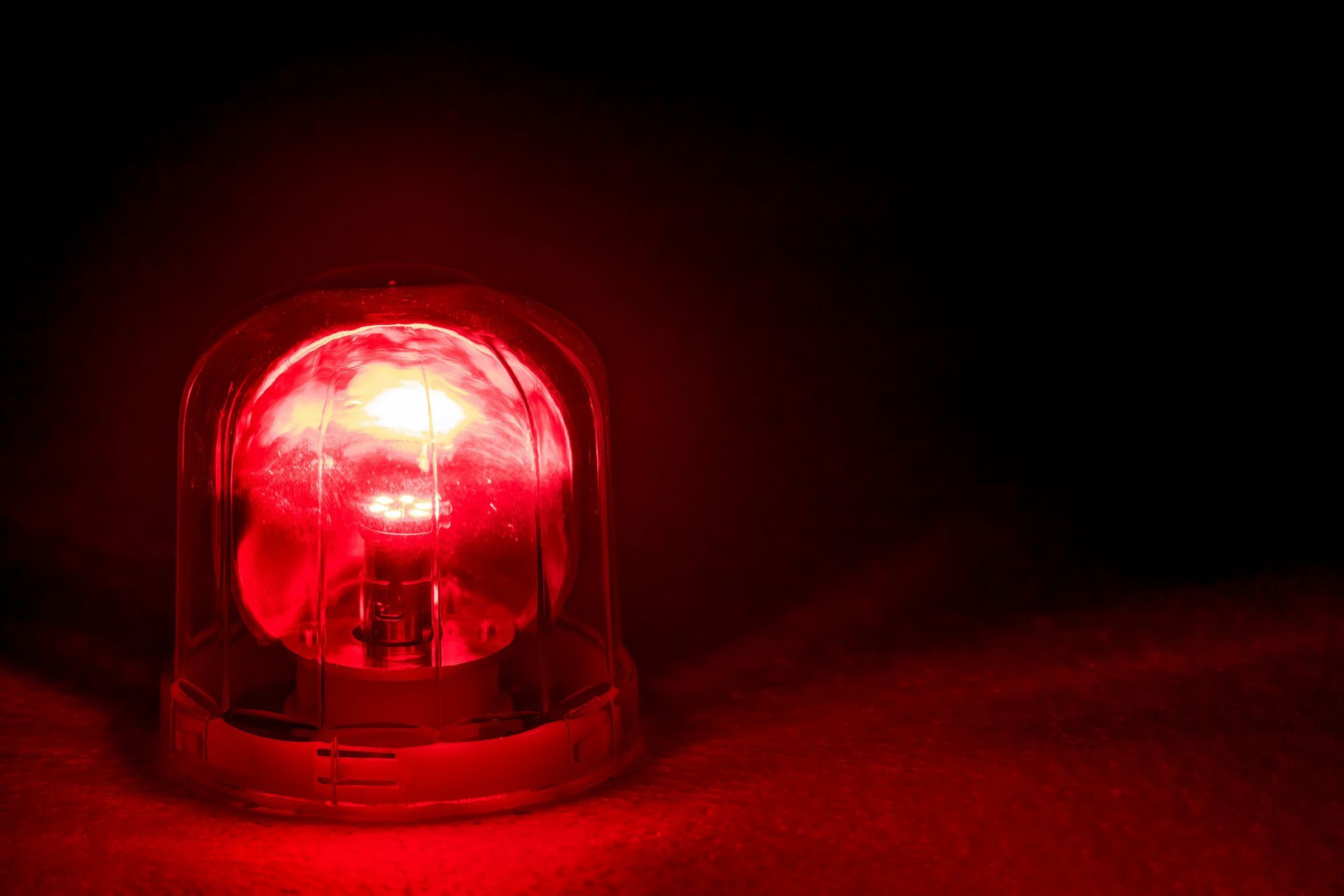 A red emergency light is lit up in the dark.