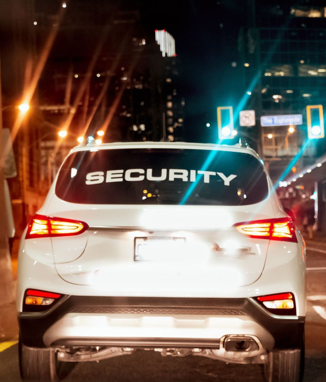 A white car with the word security on the back window