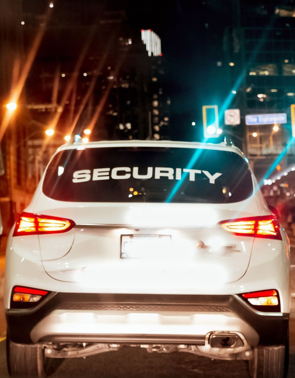 A white car with the word security on the back window