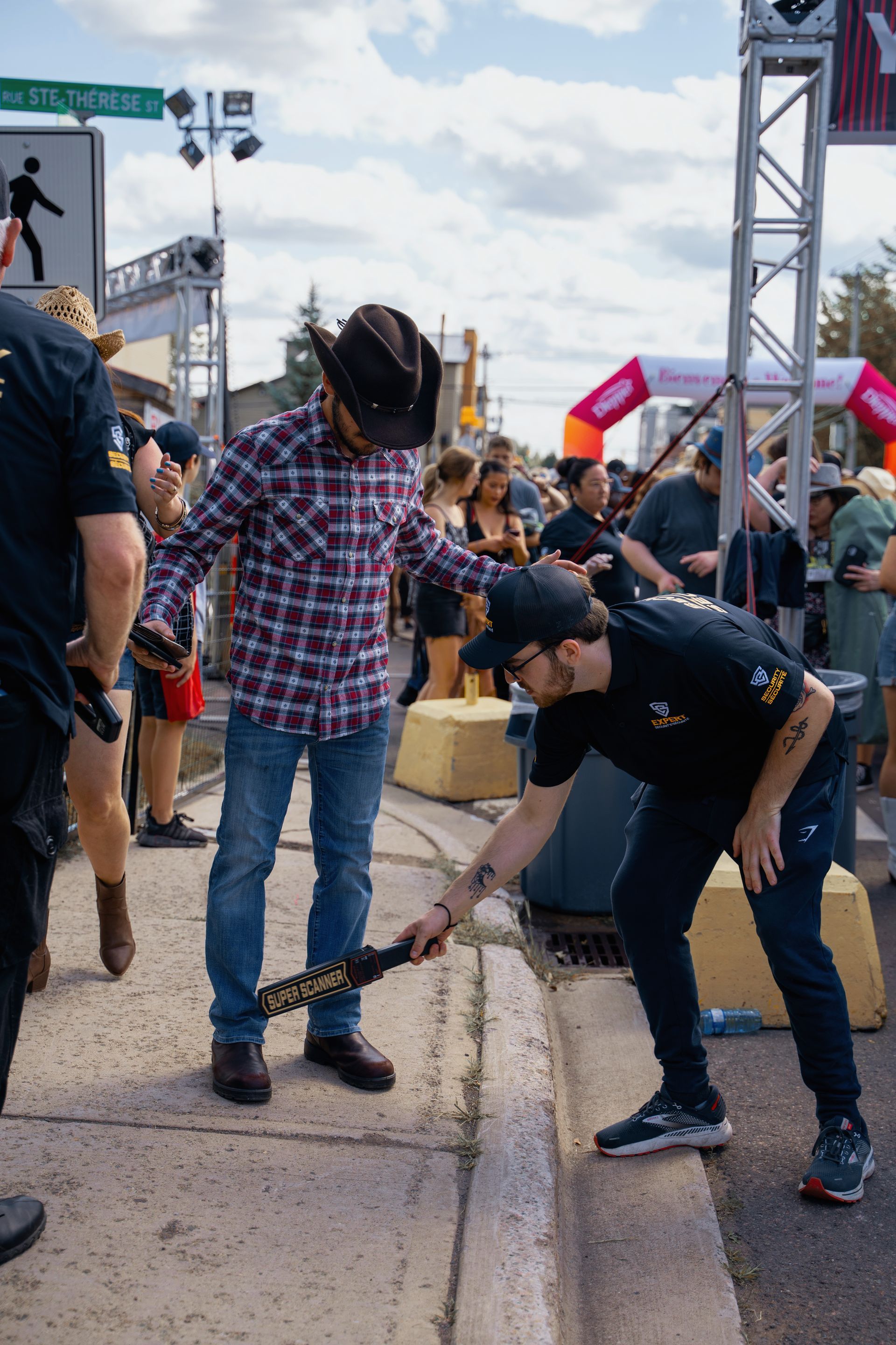 A man in a cowboy hat is standing next to another man holding a guitar.