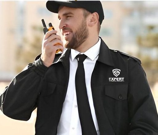 A man in a security uniform is talking on a walkie talkie