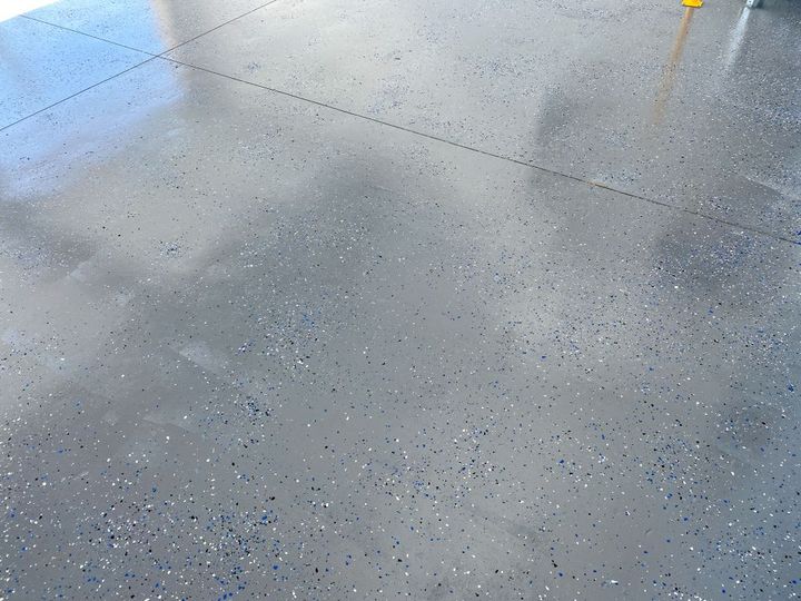 Gray speckled concrete floor with a few small yellow and orange markings