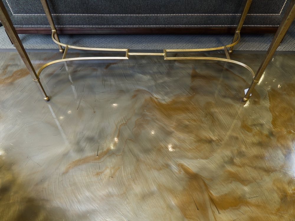 Two curved metal tubes on a wet reflective floor beneath a mesh barrier