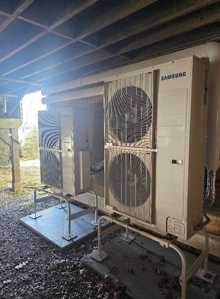 Samsung HVAC units mounted outdoors, under a building.