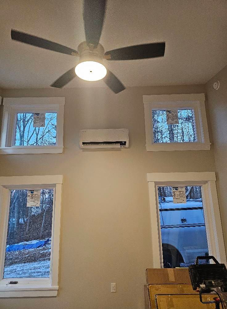 Interior room with four windows and an air conditioning unit. Ceiling fan is visible.