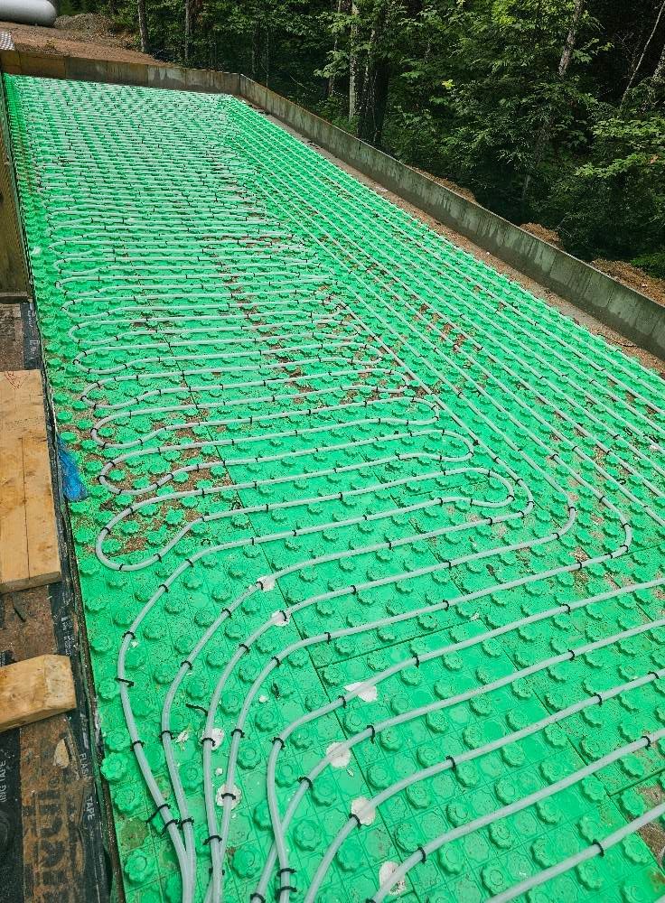Green underfloor heating system installed on a foundation, ready for concrete.