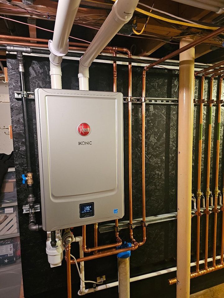 Rheem tankless water heater with copper piping in a basement. White and copper colors dominate the plumbing.