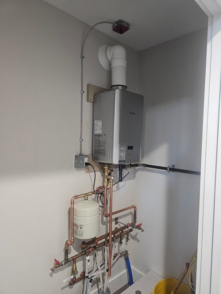 Water heater with copper pipes and ventilation system in a corner room.
