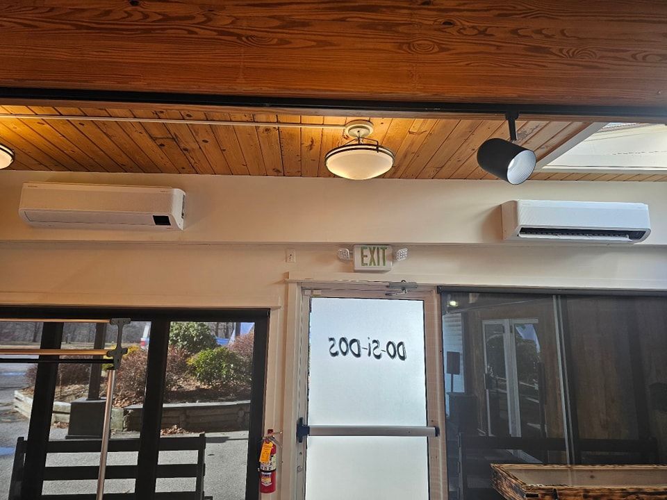 Two air conditioners above a doorway with the number 