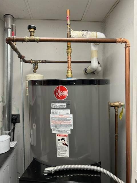 A water heater with copper pipes in a utility room.