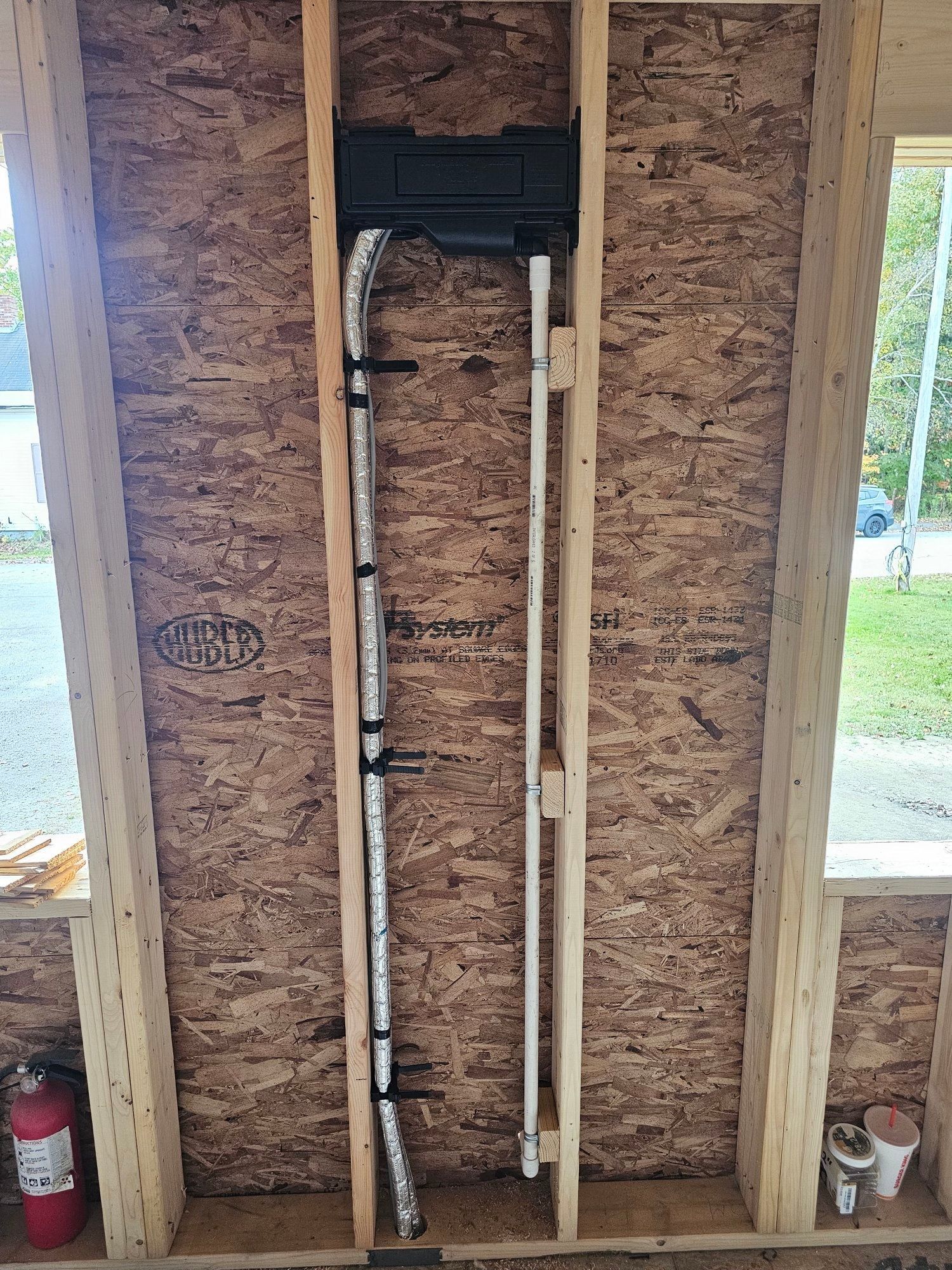 Electrical conduits and box installed in a wall frame during construction.
