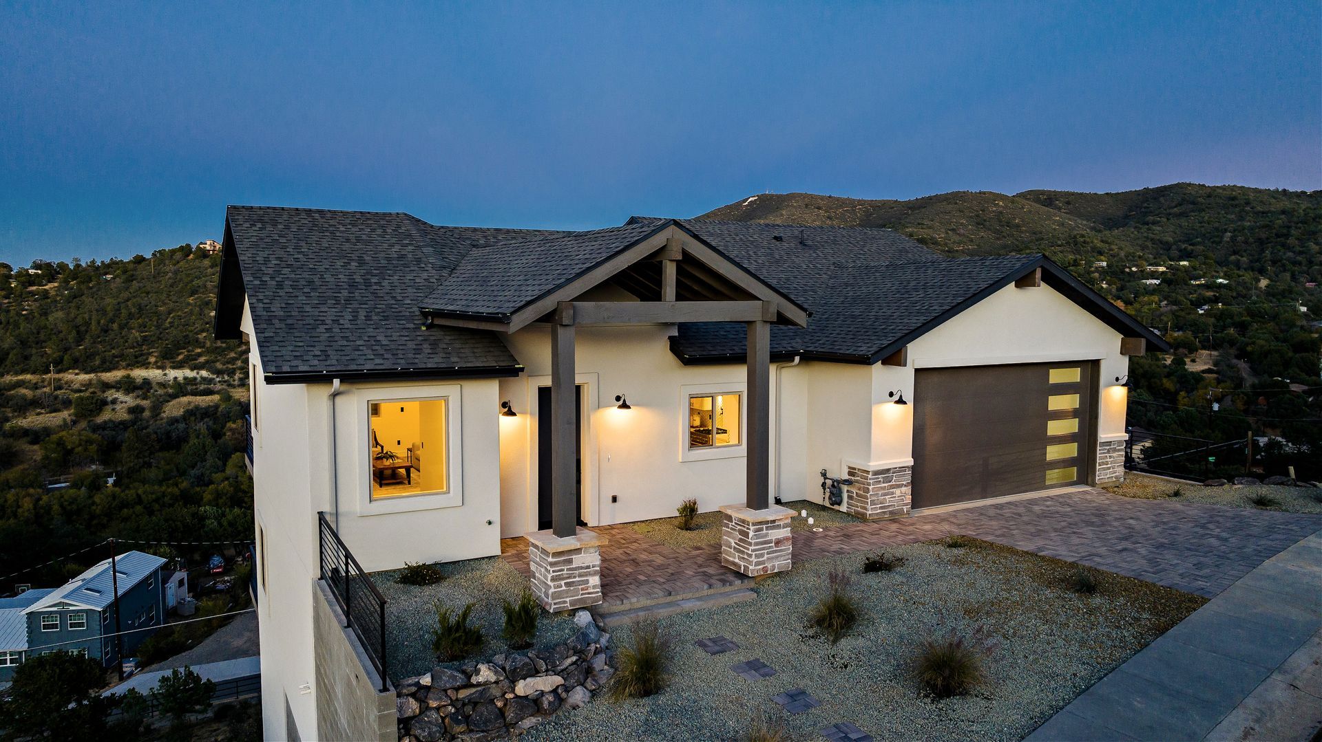 Close-up view of a custom cliffside home on Jordin Drive in Prescott, AZ, illuminated at night, highlighting architectural details and high-end finishes.