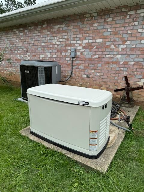 Generator and AC unit next to a brick building.
