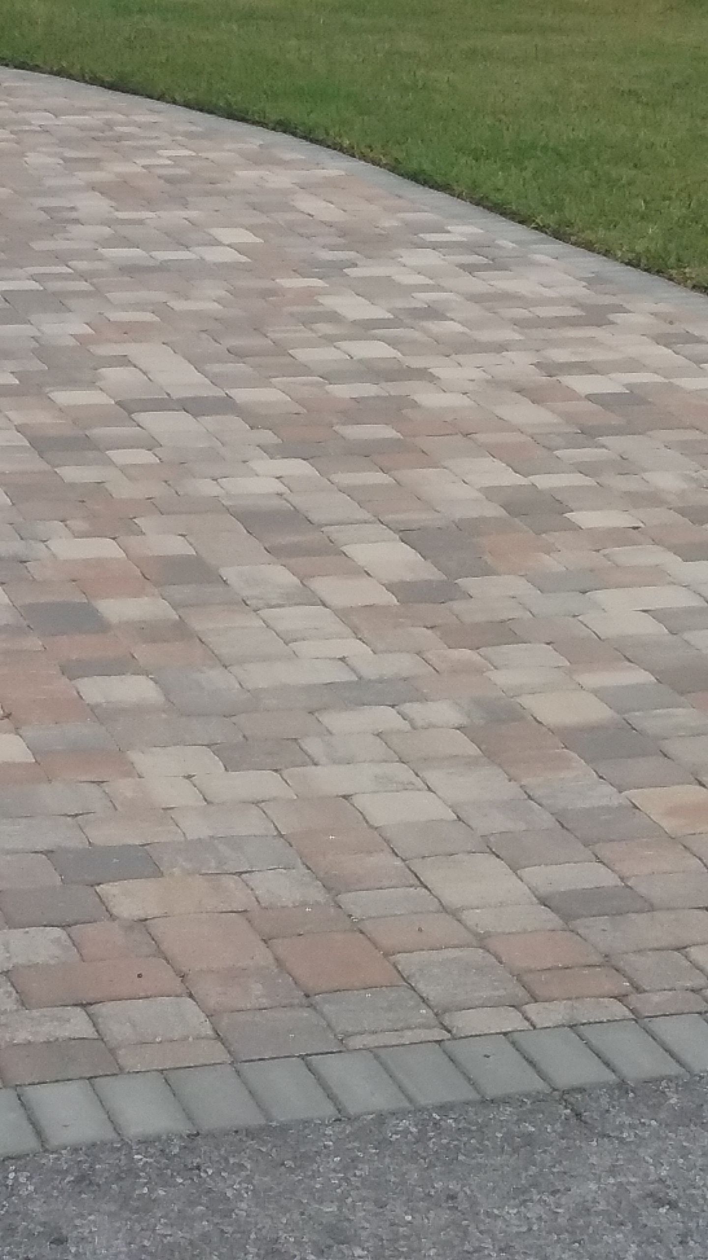 Two men are installing artificial grass in a backyard.