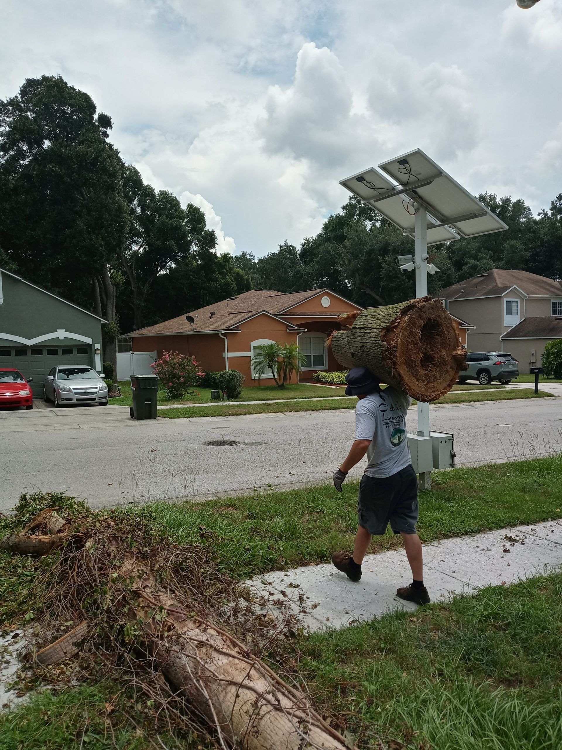 A man is working on a tree chipper in the woods.