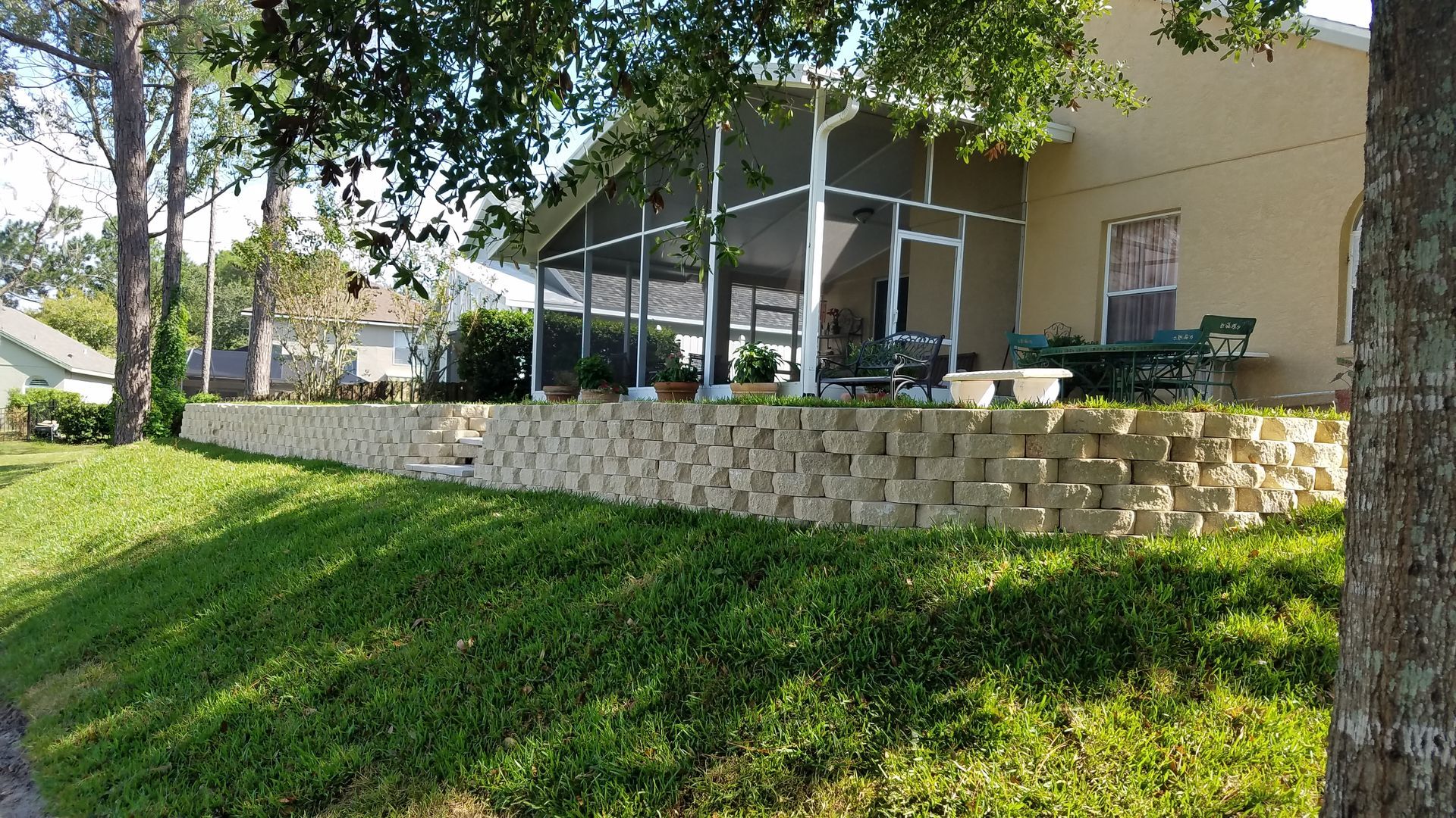 A house with a stone wall and a walkway leading to it.