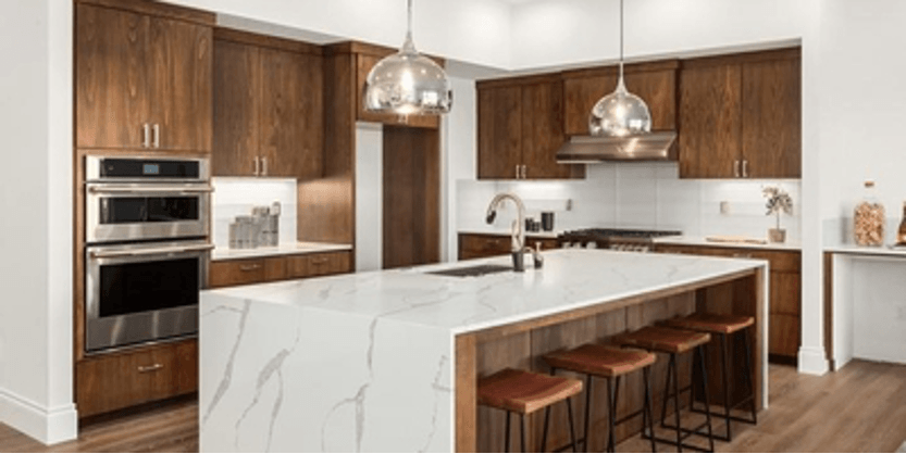 A kitchen with wooden cabinets , stainless steel appliances , and a large island.