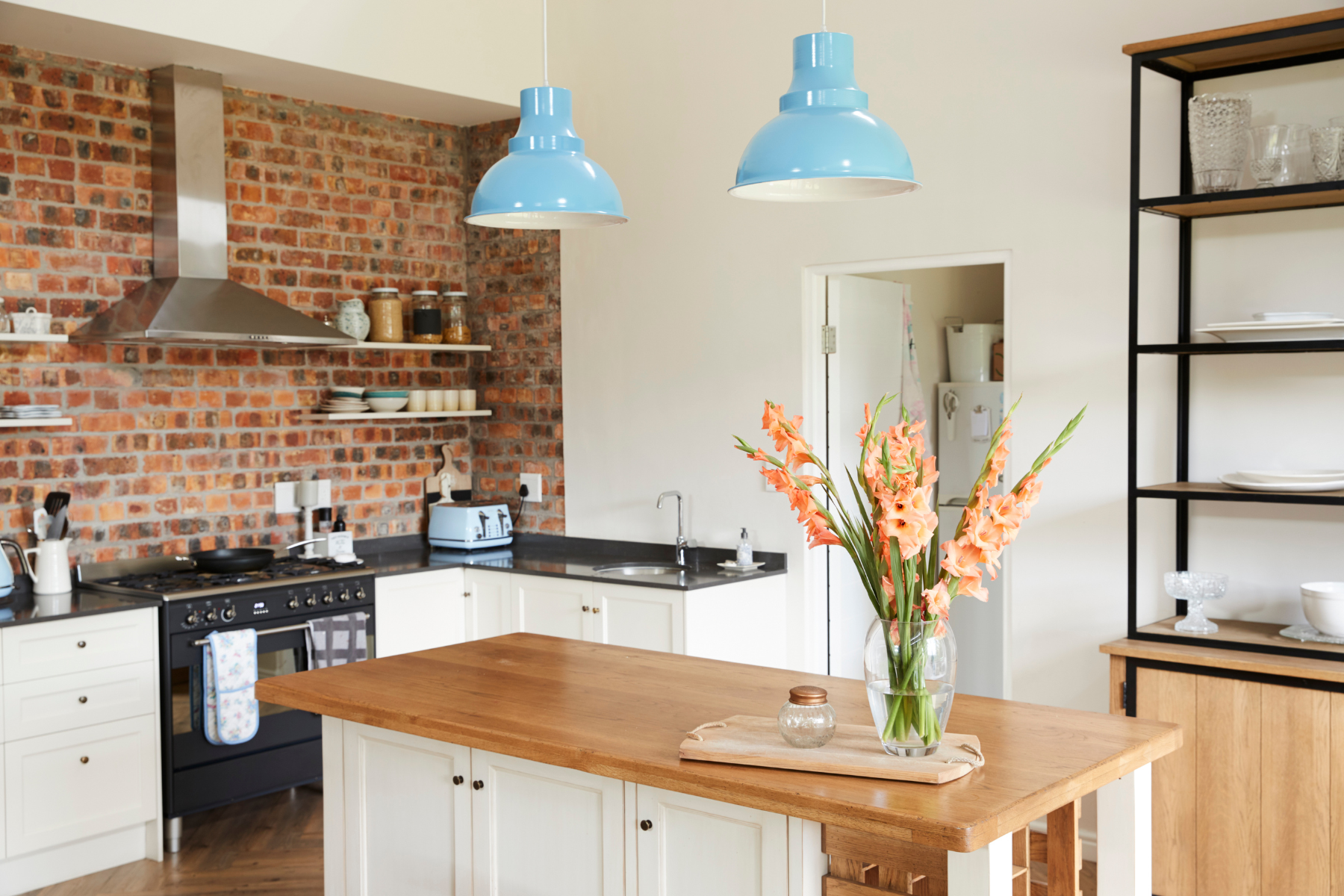 A kitchen with a wooden island and a vase of flowers on it.
