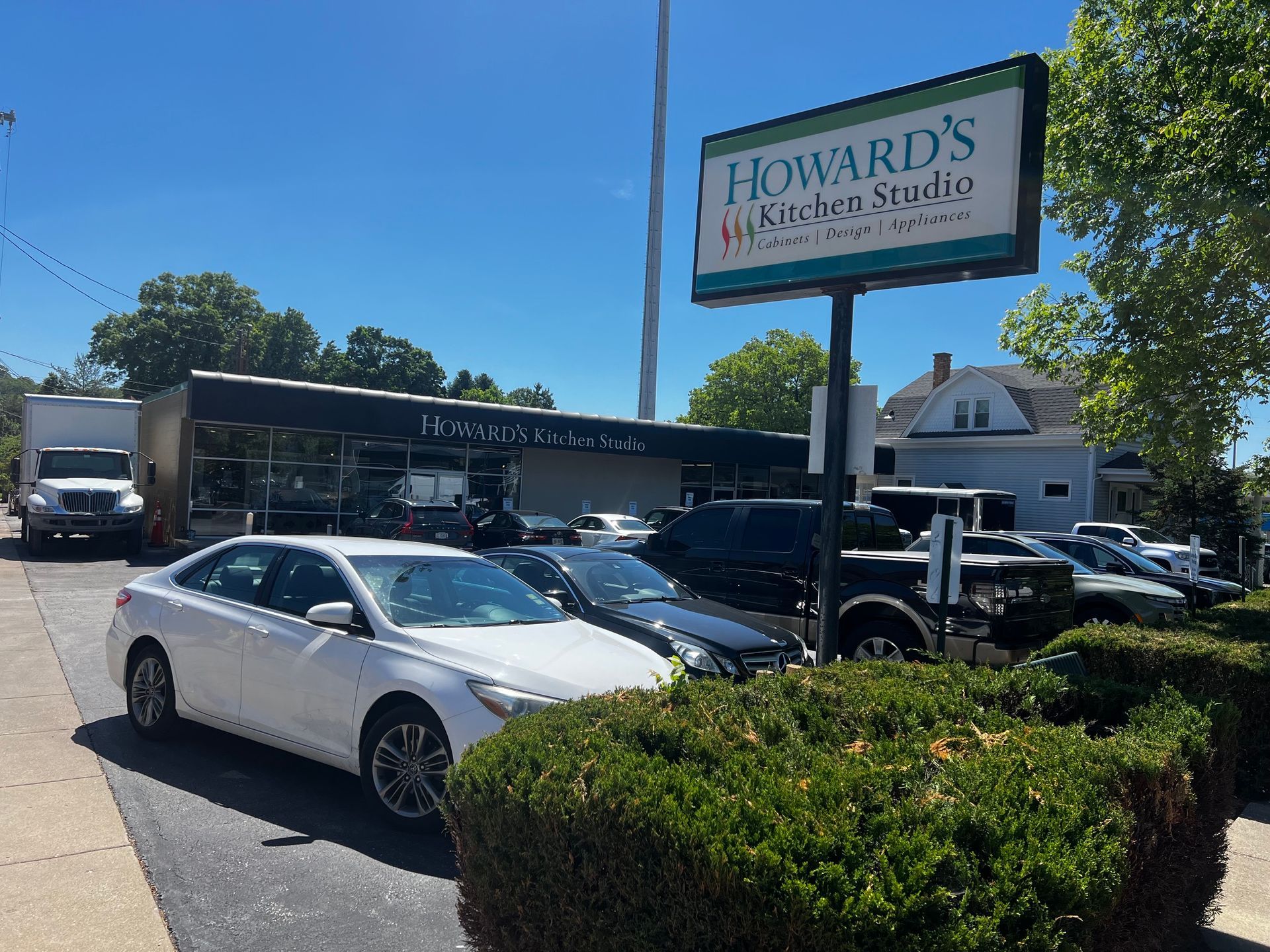 Howard’s Restaurant sign above parked cars on a sunny street corner in Cincinnati, OH