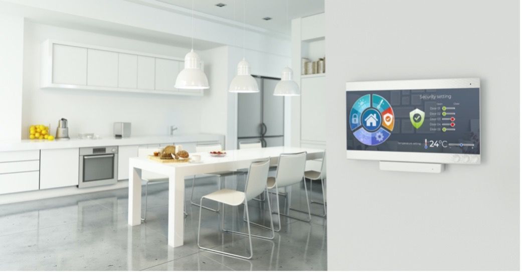 A kitchen with a table and chairs and a television on the wall.