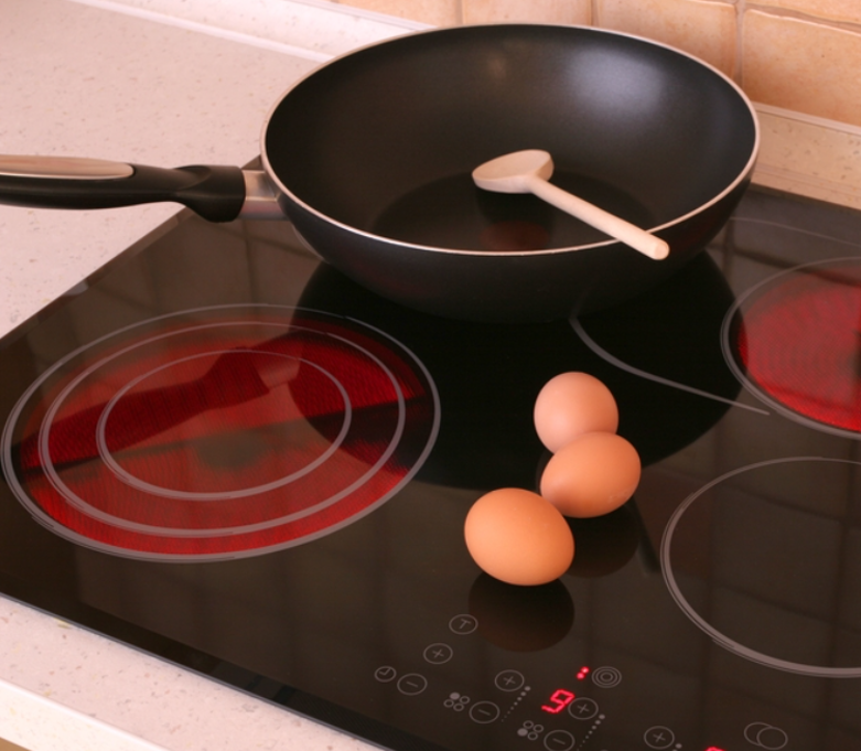 Eggs and a frying pan on a stove that has the number 9 on it
