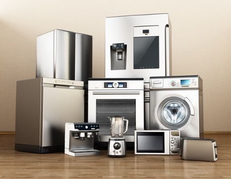 A group of stainless steel appliances are sitting on a wooden floor.