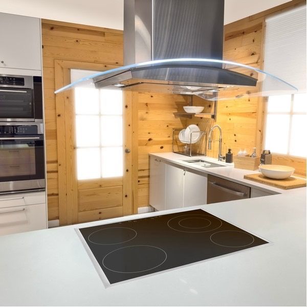A kitchen with a stove top oven and a hood