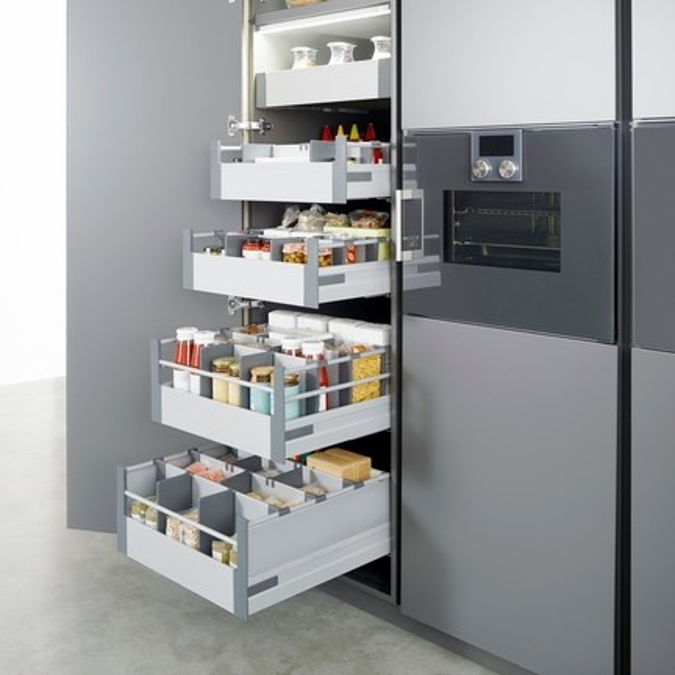 A kitchen with lots of drawers and a fridge