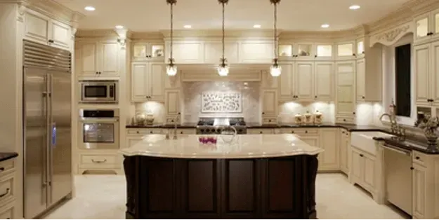 A kitchen with white cabinets and a hood above the cabinets.