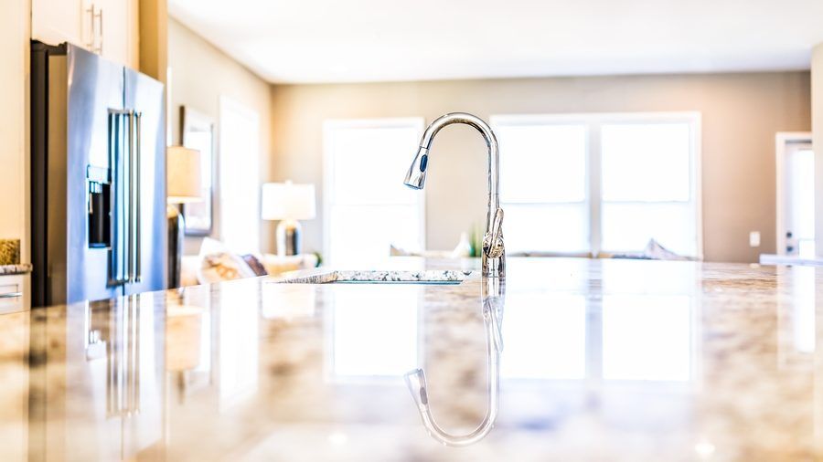 A kitchen with a sink and a refrigerator in a house.