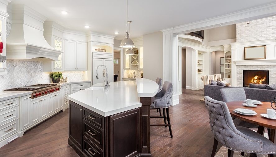 A kitchen and dining room in a house with a large island in the middle.