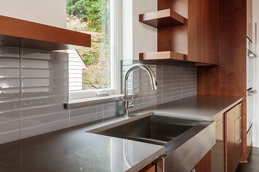 A kitchen with a stainless steel sink and a window.