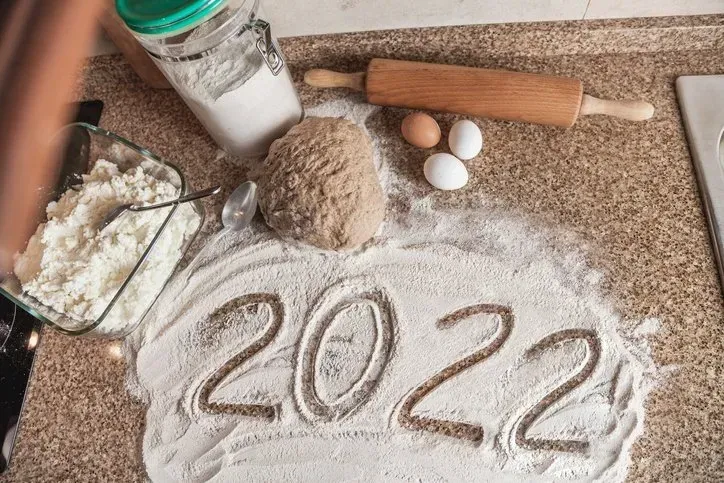 The year 2022 is written in flour on a counter.