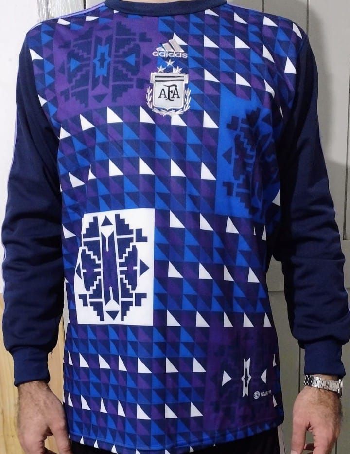 Una persona que lleva puesta una camiseta de manga larga de Argentina con un estampado geométrico azul y morado