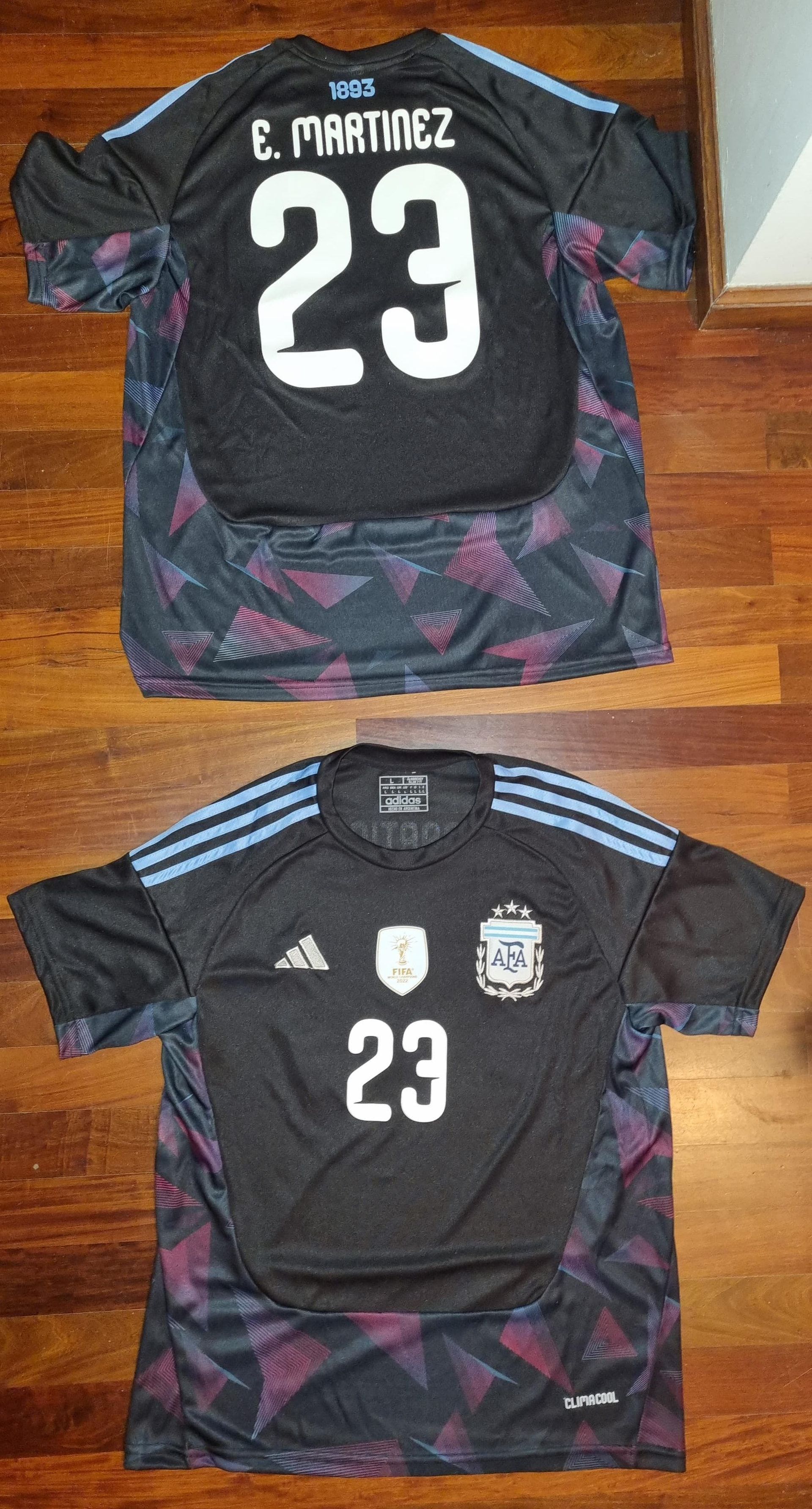 Dos camisetas negras de portero argentino de E. Martínez expuestas sobre un suelo de madera, vistas frontal y trasera.