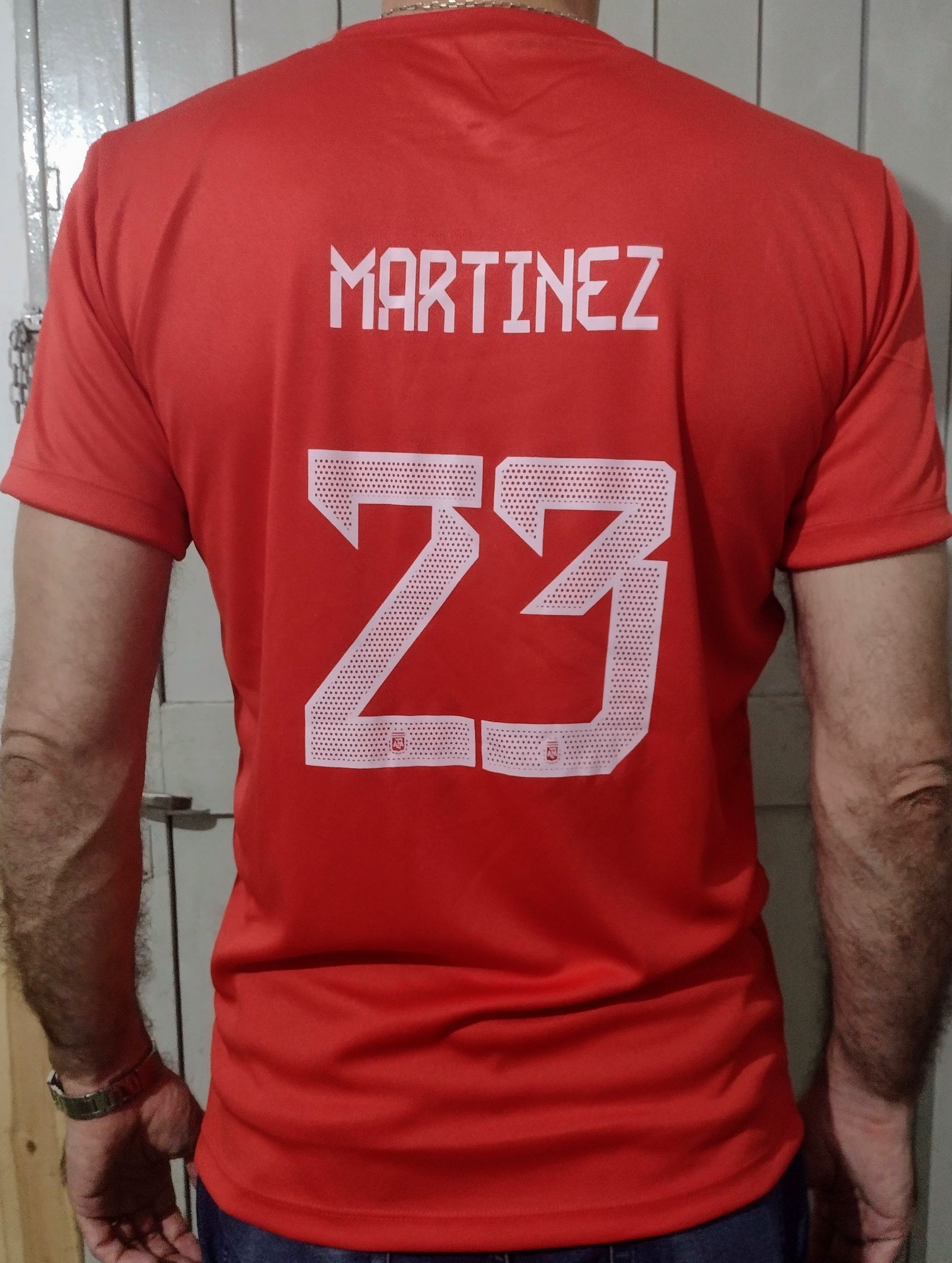 Una persona lleva puesta una camiseta roja de la selección argentina