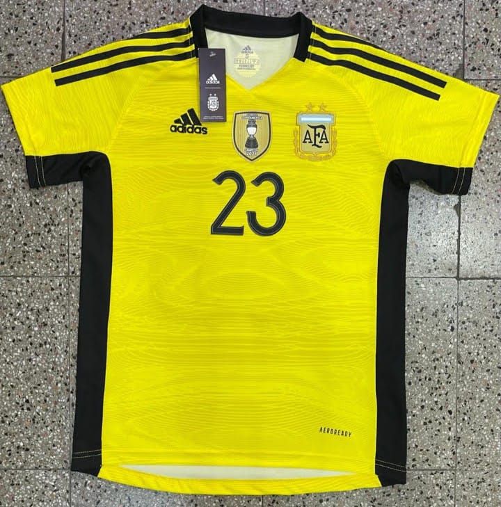 Una camiseta amarilla de portero de Argentina con ribetes negros, el escudo de la AFA y el número 23 en la parte delantera.