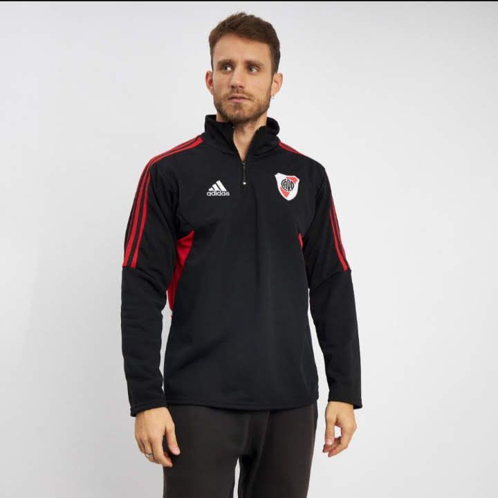 Un hombre lleva una chaqueta de entrenamiento negra de Adidas