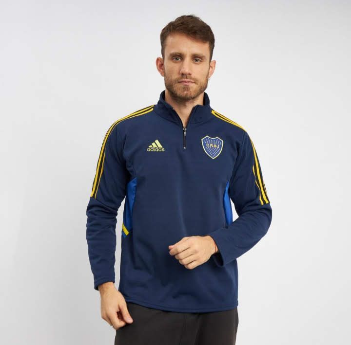 Un hombre lleva una chaqueta de entrenamiento negra de Adidas