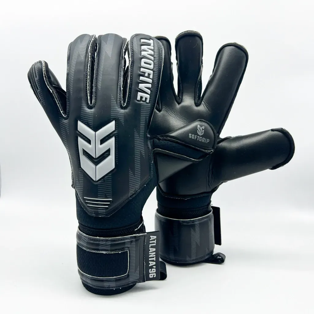 Un par de guantes de portero negros con logotipos blancos y las inscripciones 