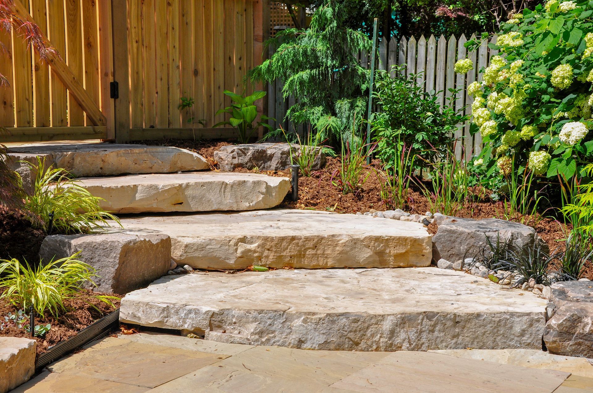A Stone Staircase Leading up To a Wooden Fence in A Garden - Kinston, NC - Garden Gator Landscape & Design A Stone Staircase Leading up To a Wooden Fence in A Garden - Kinston, NC - Garden Gator Landscape & Design