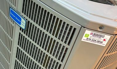 Close-up of a metal HVAC unit with grilles and service labels.