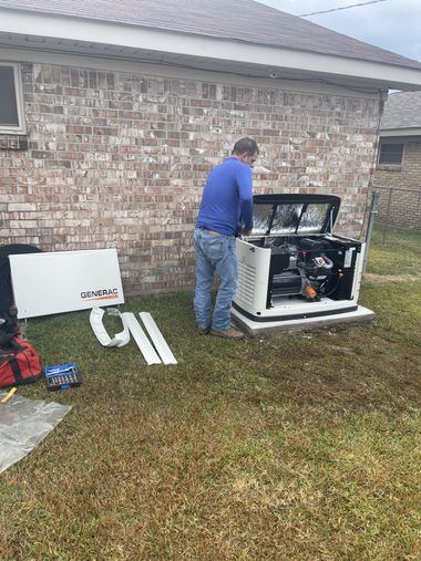 Man in blue shirt inspecting a white generator beside a brick house on a lawn