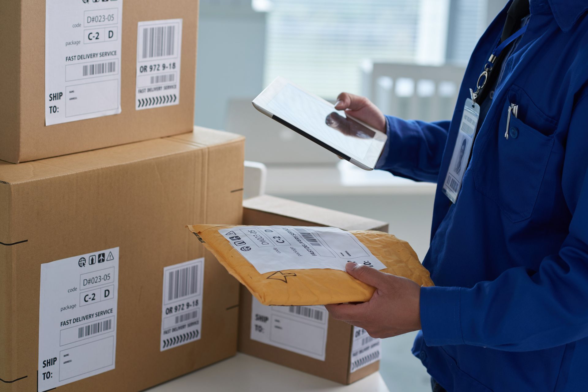 Commercial courier scanning a package for delivery with a digital tablet
